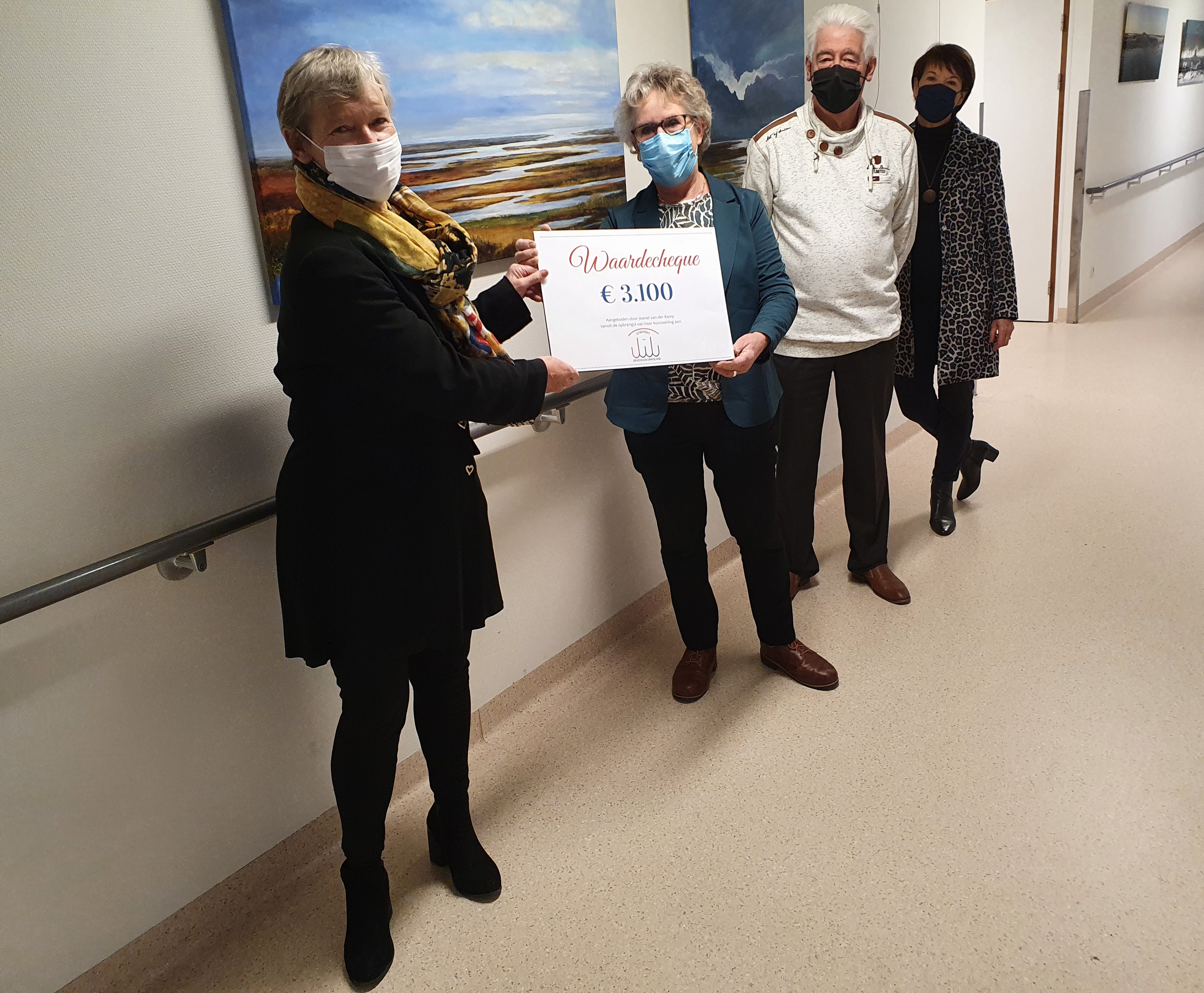 Kunstenares Jeanet van der Kamp overhandigt de cheque